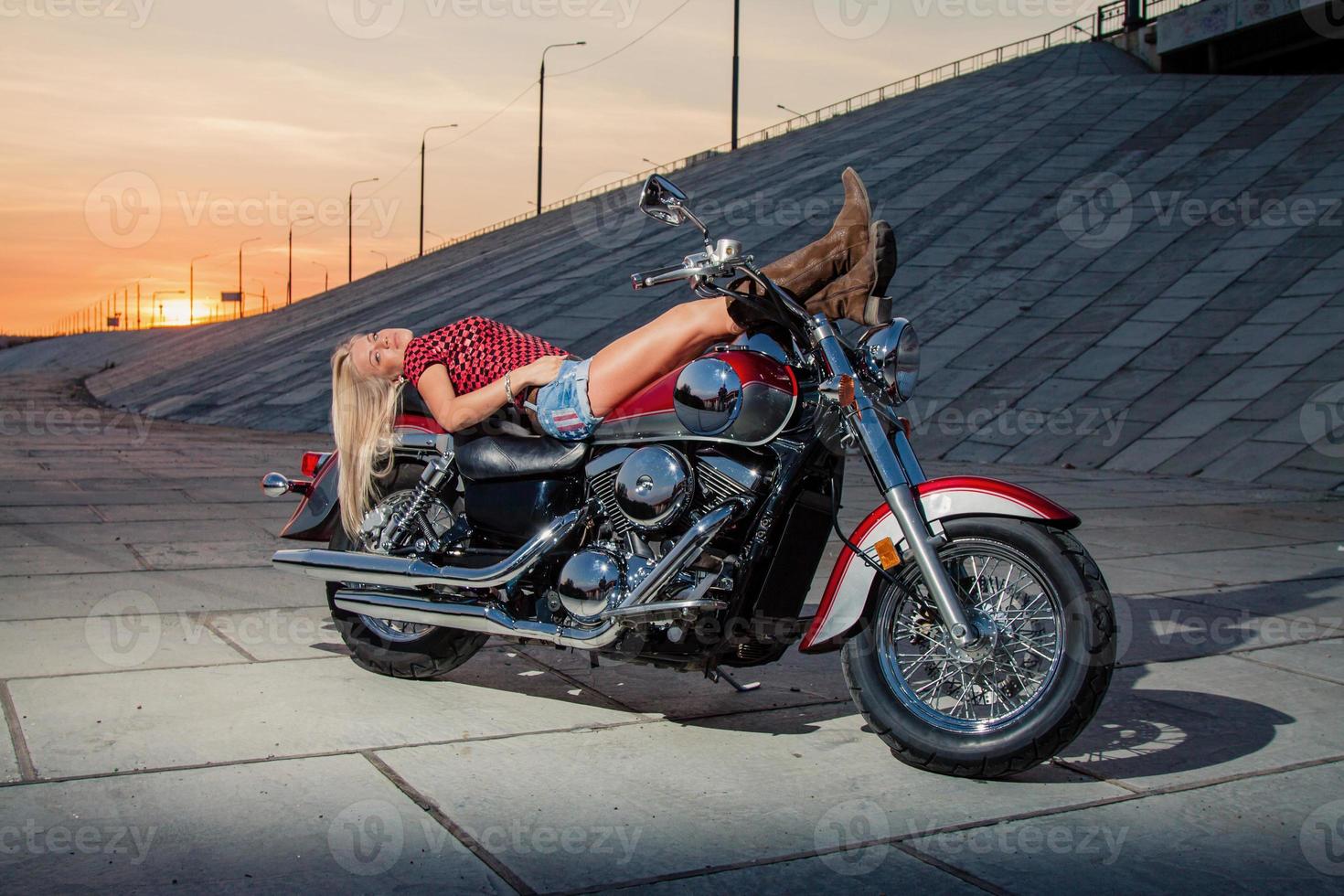 blonde sexy allongée sur sa moto photo