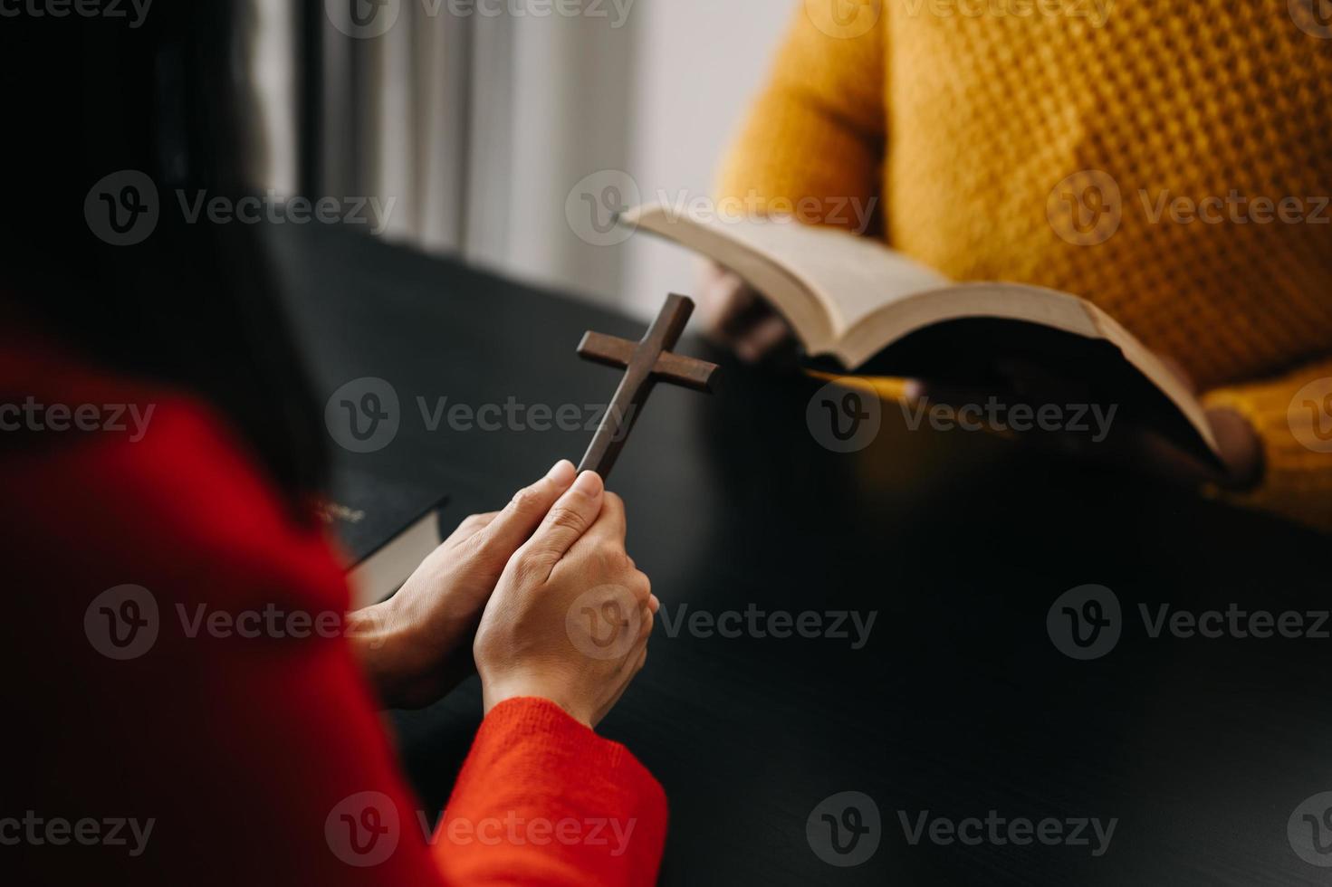 deux personnes lisent et étudient la bible à la maison et prient ensemble. étudient la parole de dieu avec des amis. photo