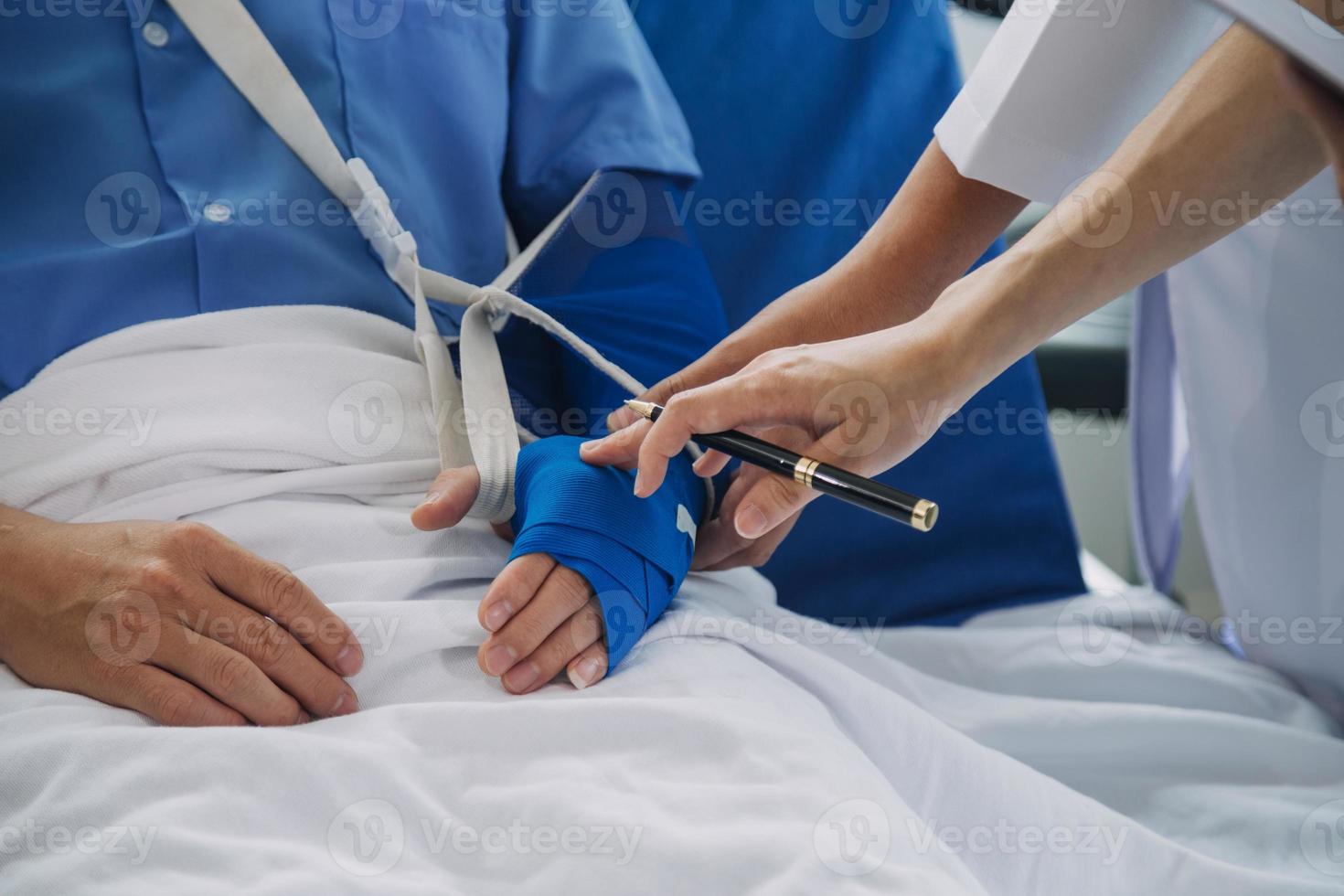 blessé patient montrant médecin cassé poignet et bras avec bandage dans hôpital Bureau ou urgence chambre. entorse, stress fracture ou répétitif souche blessure dans main. infirmière portion client. premier aide. photo