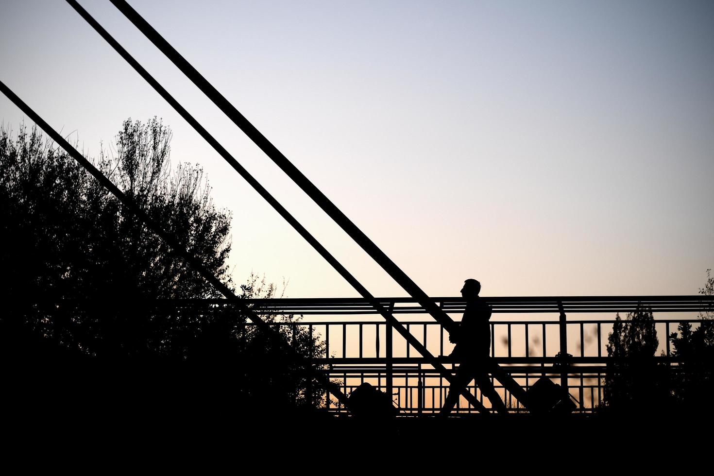 homme qui marche vue contre le ciel. silhouette humaine sur le pont. photo