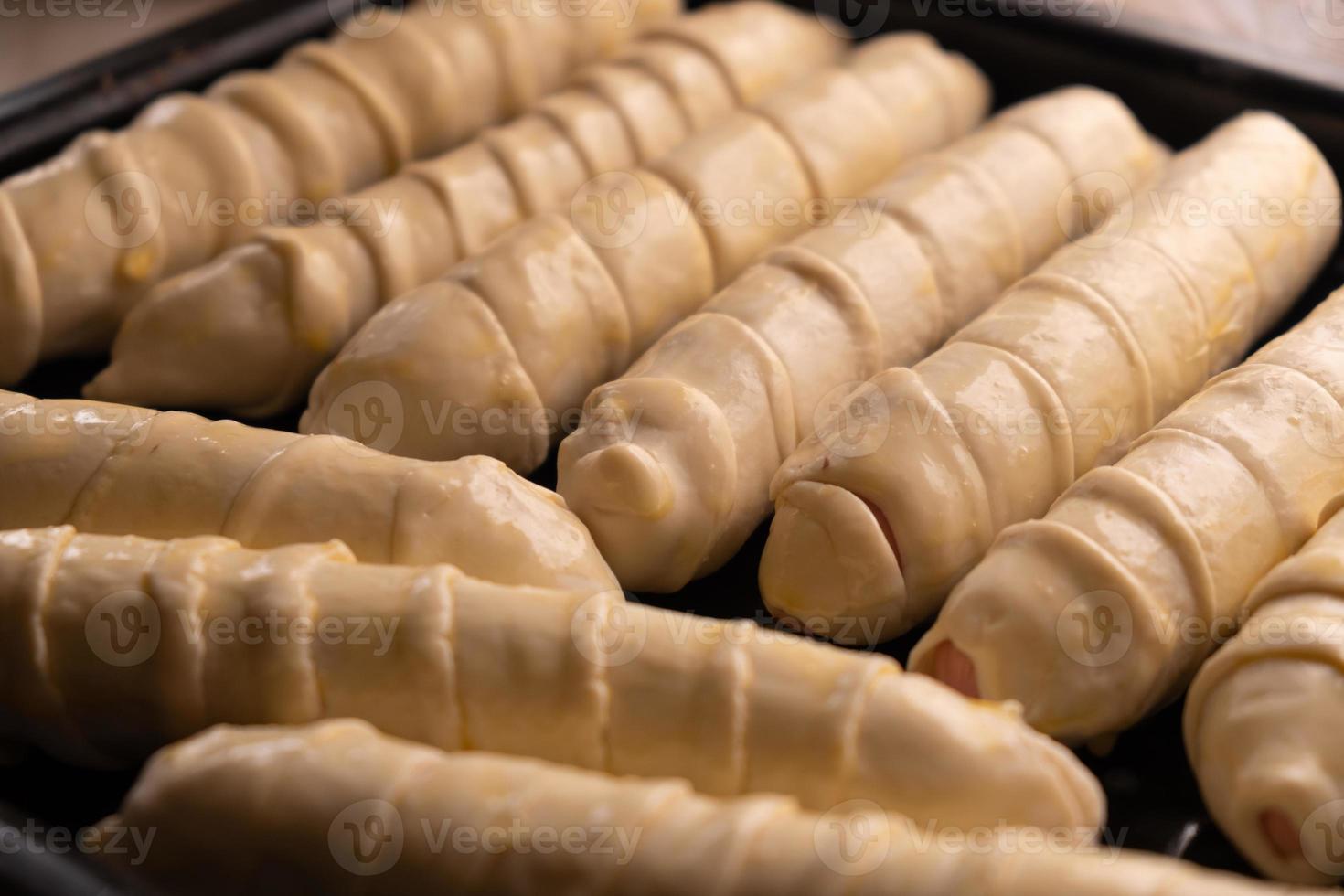 cuire les saucisses dans la pâte à l'aide de pâte feuilletée. photo