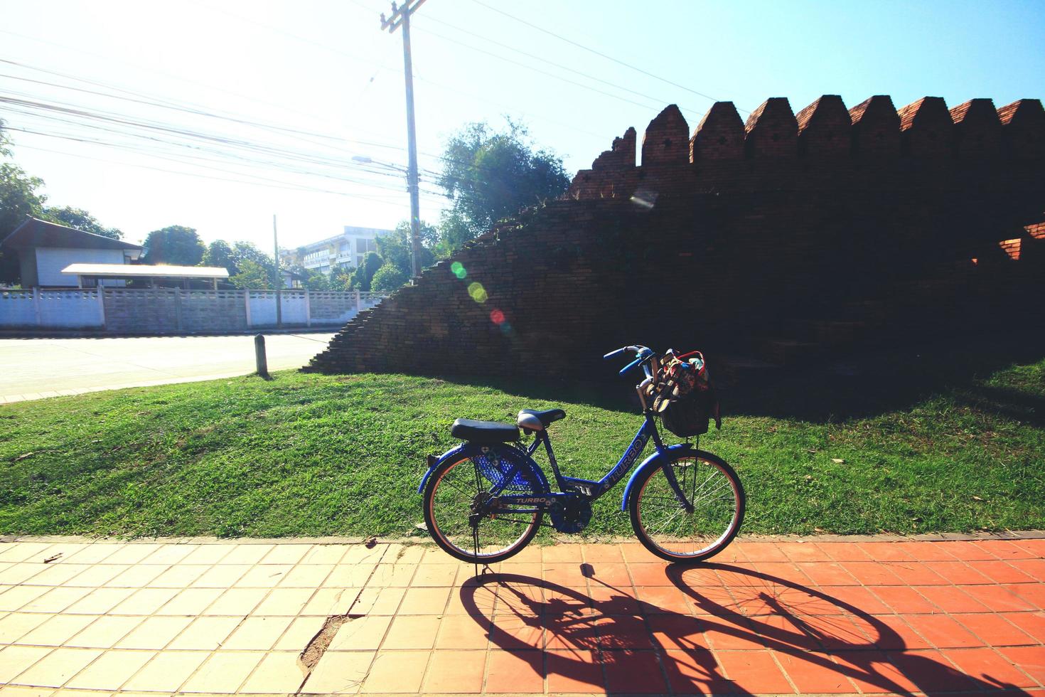 ancien bleu bicyclette parking dans jardin près historique ville brique mur. photo