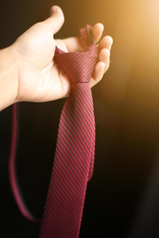 femme main en portant intelligent rouge cravate avec Naturel lumière du soleil photo
