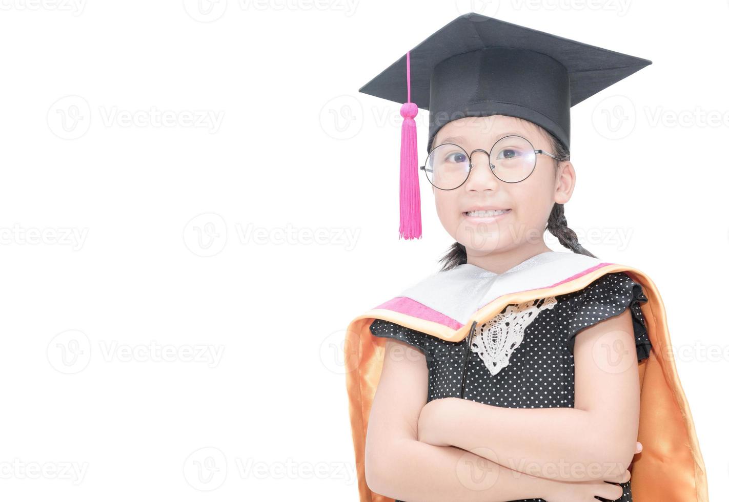 mignonne asiatique fille étudiant dans l'obtention du diplôme casquette sourire isolé photo