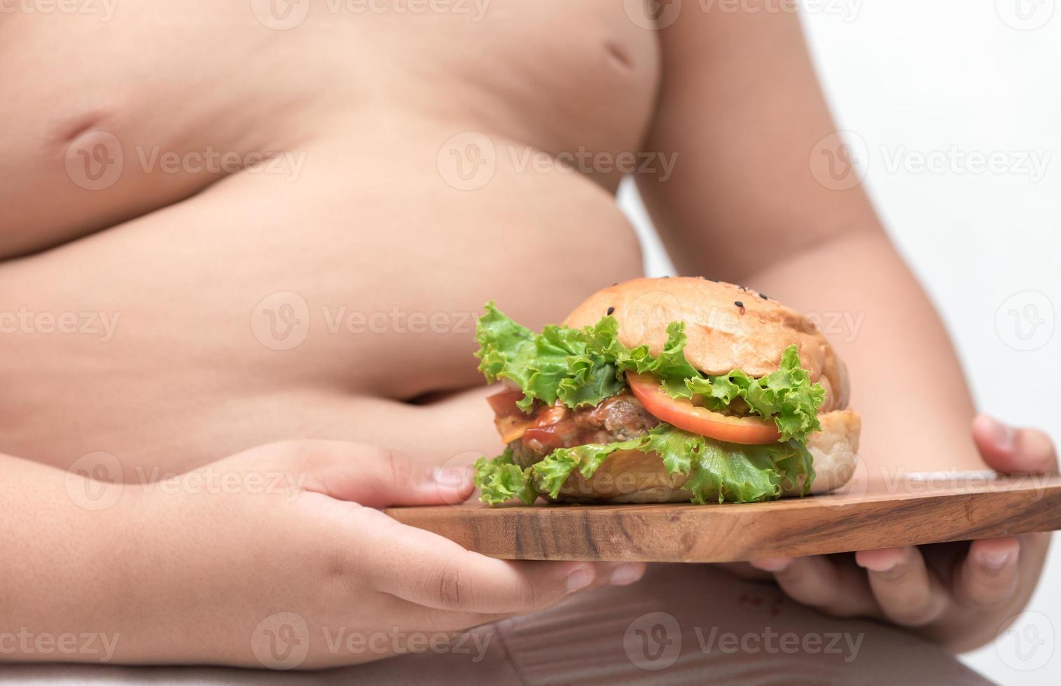 porc Hamburger sur bois assiette et obèse garçon Contexte isolé photo