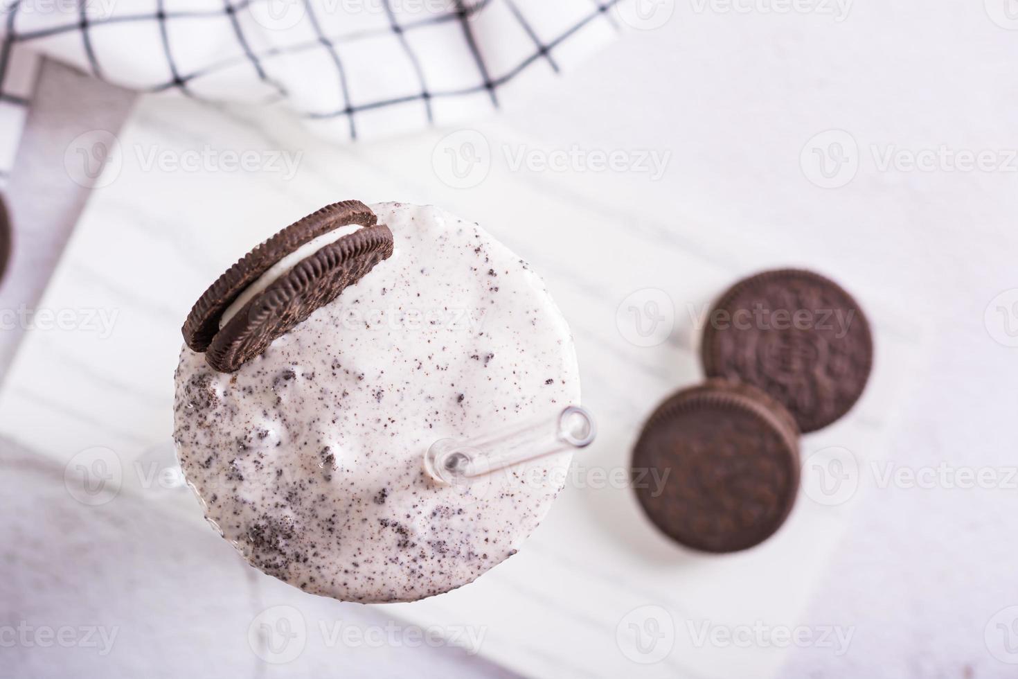 proche en haut de Milk-shake de Chocolat oreo biscuits et la glace crème dans une verre avec une paille Haut vue photo