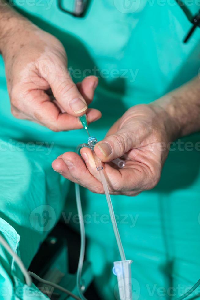 chirurgical équipe en train de préparer leur patient pour chirurgie, anesthésiste donne anesthésie à une patient photo