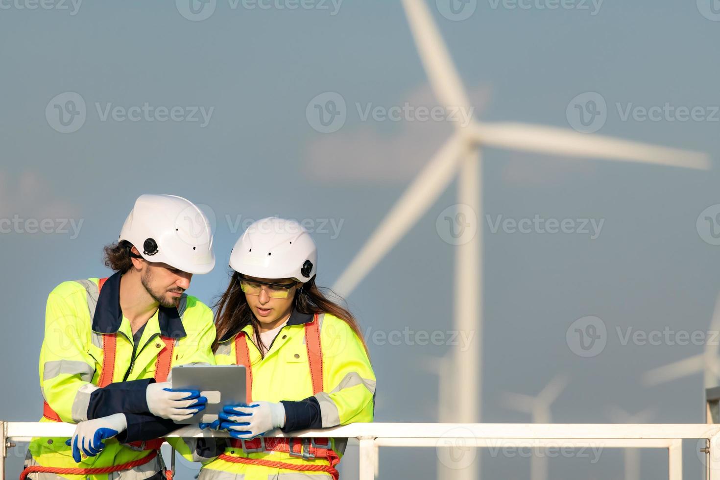 homme et femelle ingénieur stationné à le Naturel énergie vent turbine placer. avec du quotidien Audit Tâches de Majeur vent turbine opérations cette transformer vent énergie dans électrique électricité photo