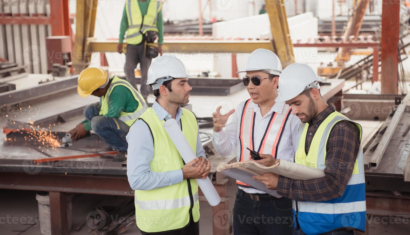 groupe de architectes, construction contremaîtres, et construction ingénieurs la revue le travail et parler à propos Comment le projet, dans le construction placer. photo