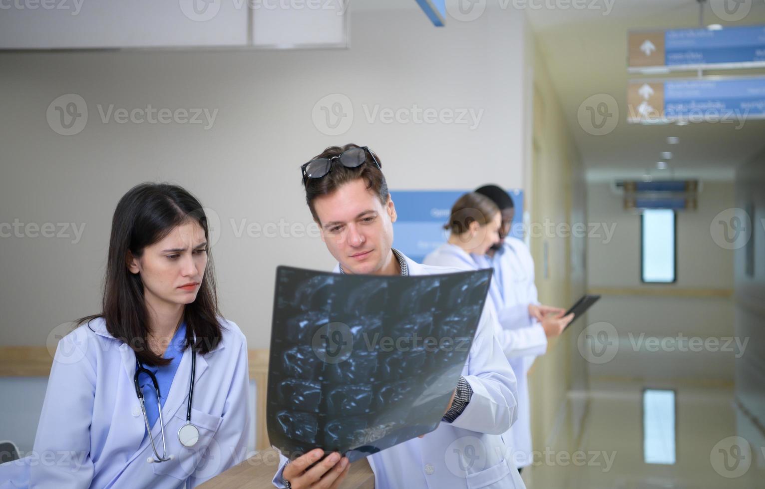médical prof et stagiaires en cours d'analyse le radiographie résultats de le les patients cerveau. avant Majeur chirurgie dans le en fonctionnement pièce photo
