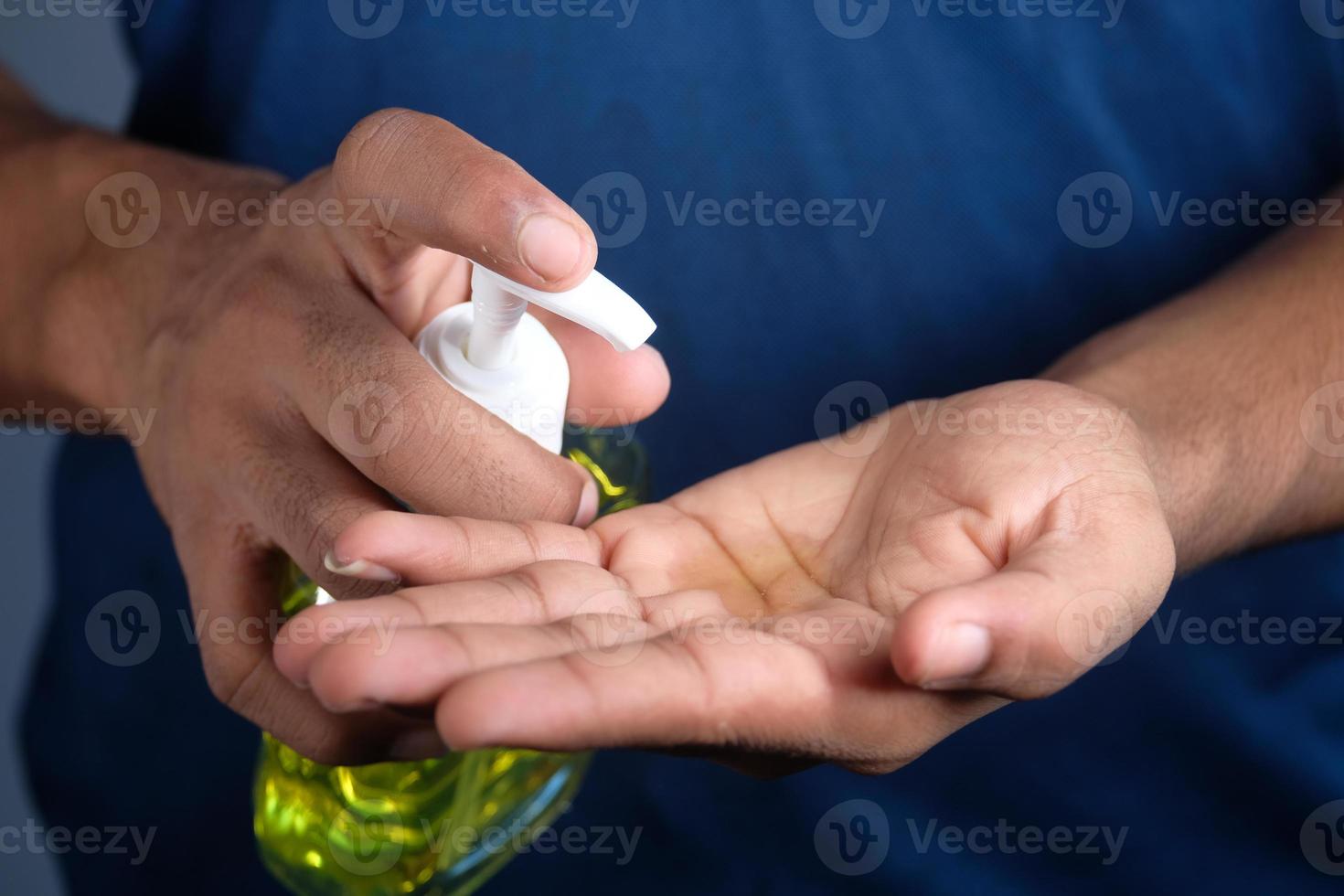 personne mettant du désinfectant pour les mains sur les mains photo