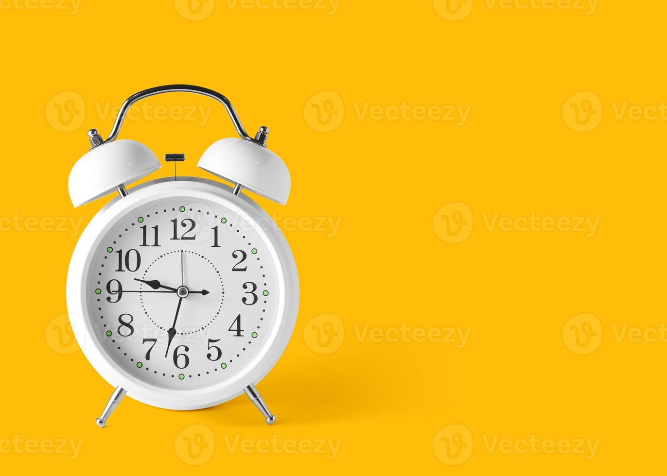 un antique blanc alarme l'horloge sur le sol avec une brillant Jaune Contexte dans pastel couleurs. minimal Créatif concept . et copie espace pour votre texte. minimal idée concept photo