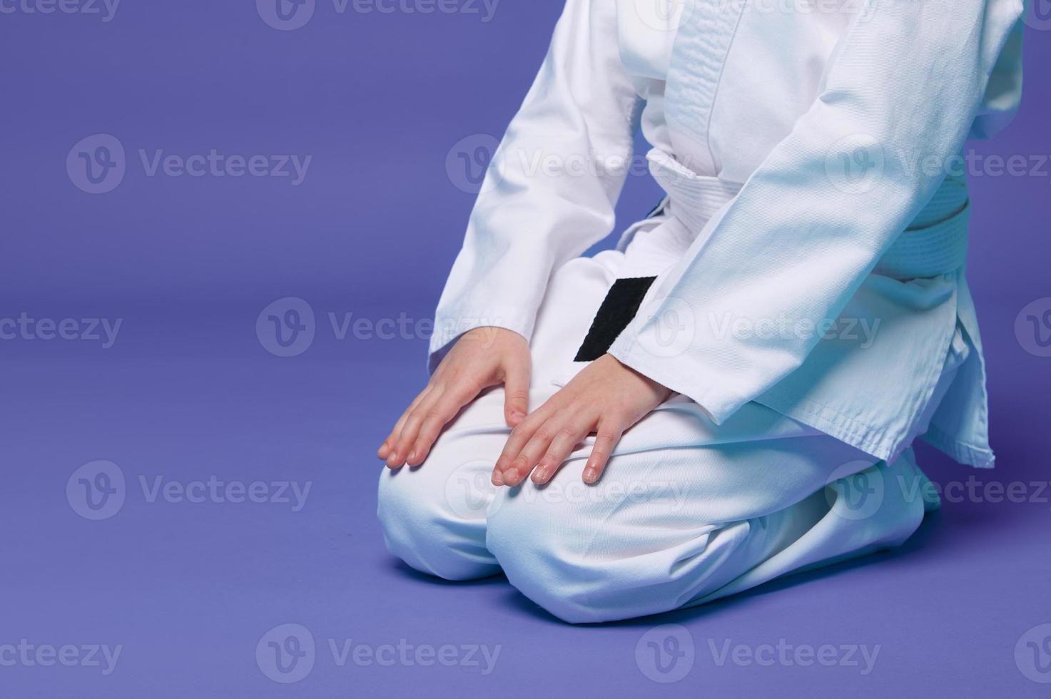 tondu vue de un aikido combattant dans une blanc kimono pendant le entraine toi de Oriental martial arts, isolé plus de violet Contexte avec copie un d espace photo