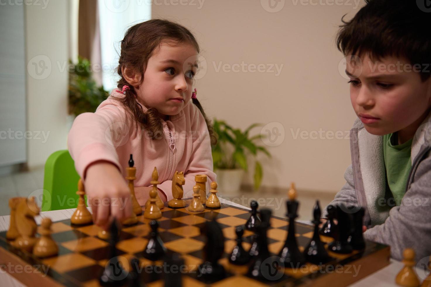 adorable caucasien enfants, deux diverse marrant des gamins adolescent garçon et enfant d'âge préscolaire fille en jouant échecs à maison. des gamins intellectuel éducation et divertissement concept, enfance, famille des relations photo