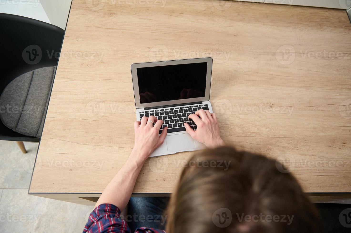 Haut vue de une affaires personne, homme d'affaire, entrepreneur, journaliste rédacteur publicitaire pigiste développeur travail à distance sur ordinateur portable, dactylographie texte sur portable avec Vide moniteur écran avec copie un d espace. photo