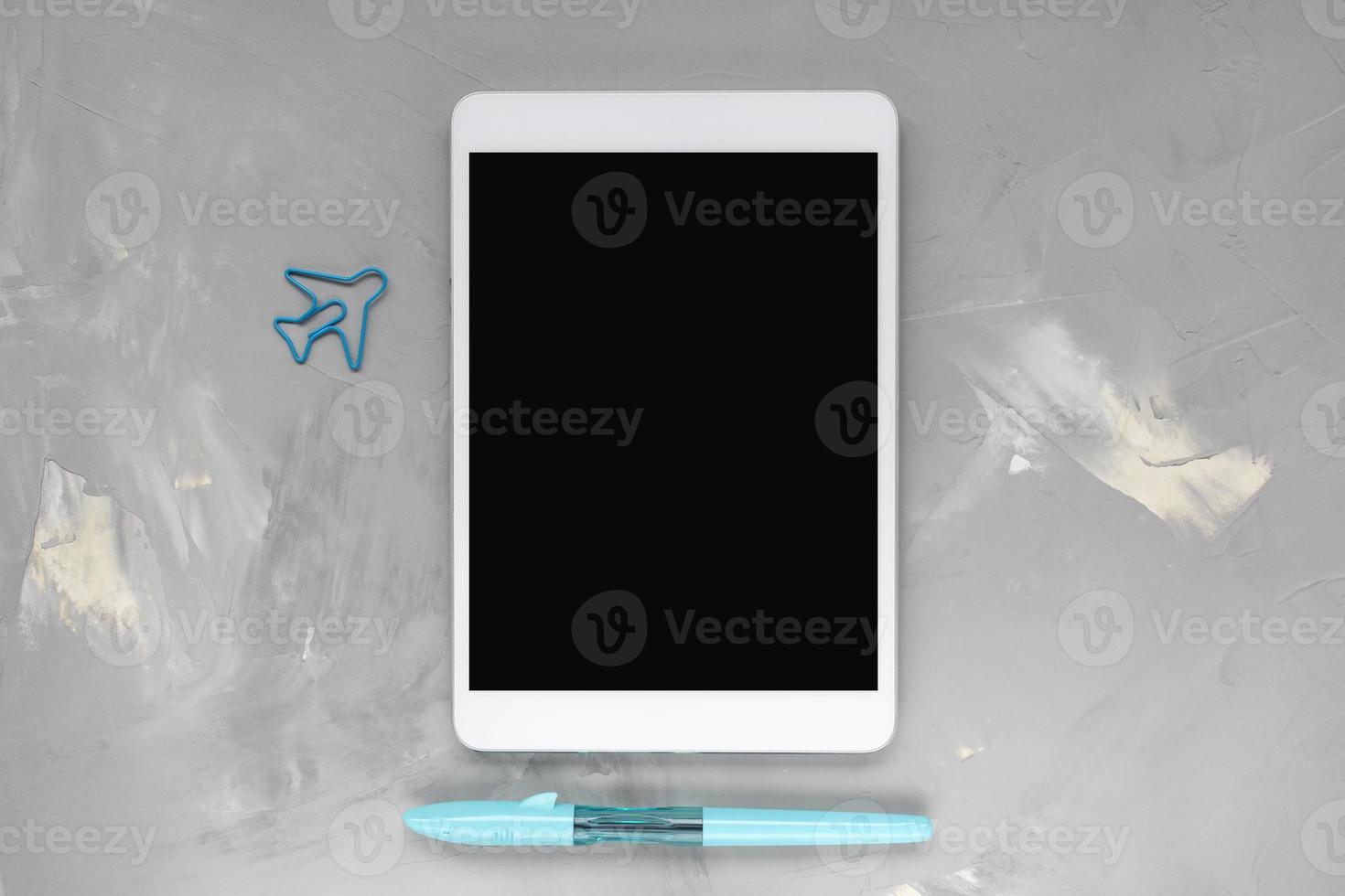 tablette, bleu stylo, avion papier agrafe sur gris photo