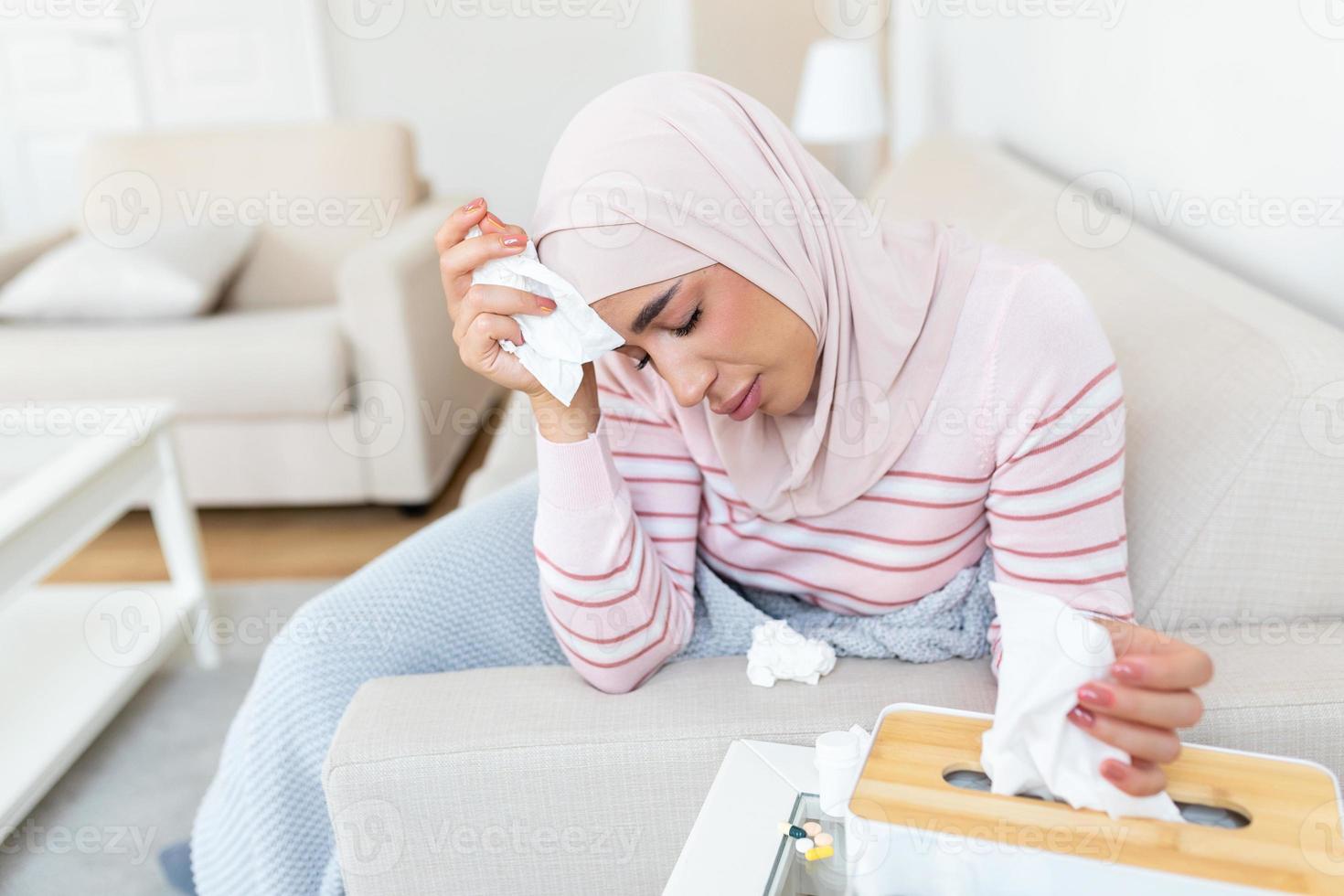 malade journée à maison. Jeune arabe femme a qui coule et commun froid. toux. fermer de magnifique Jeune femme avec hijab pris du froid ou grippe maladie. photo