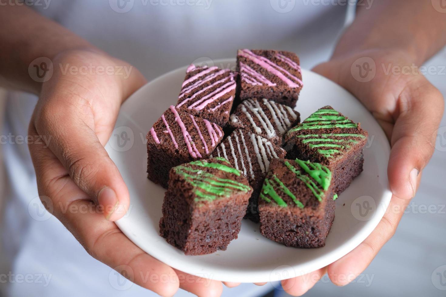 personne tenant une assiette de brownies photo