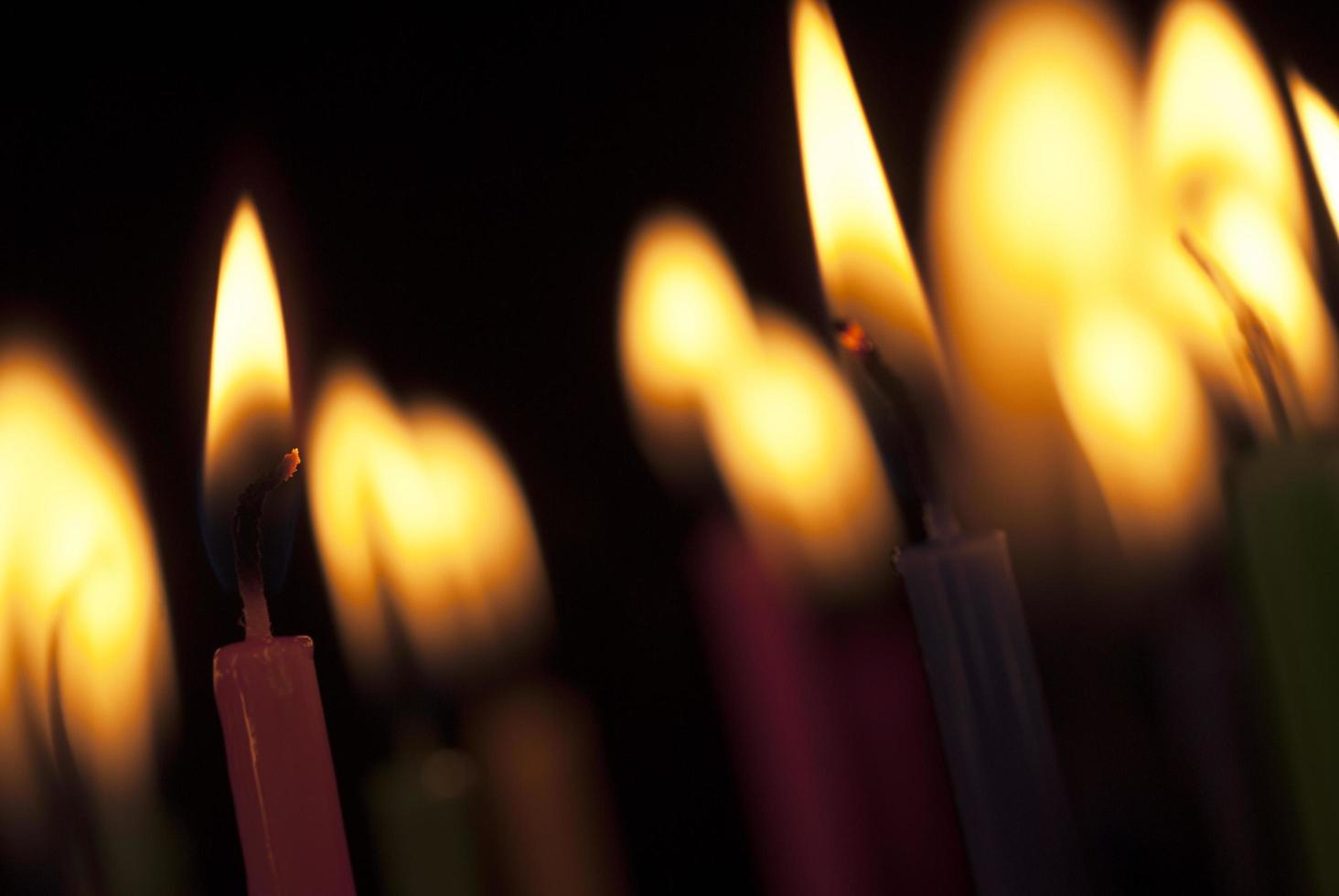 bougies allumées dans le noir. gros plan image de flammes de bougie. photo