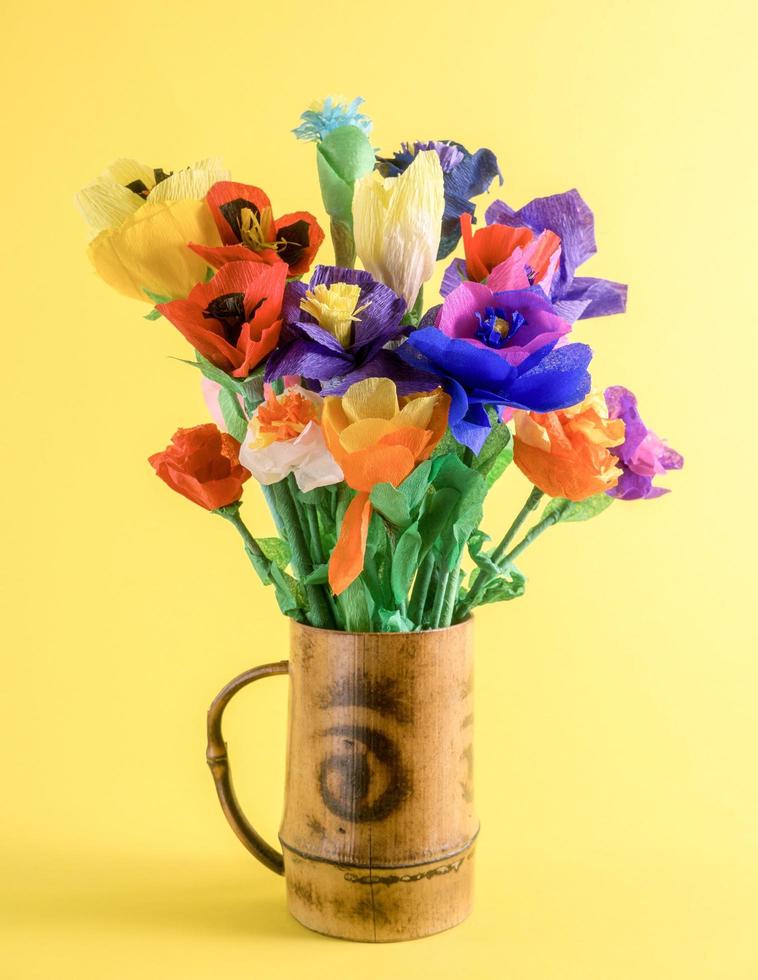 fleurs en papier colorées dans une tasse en bambou. photo