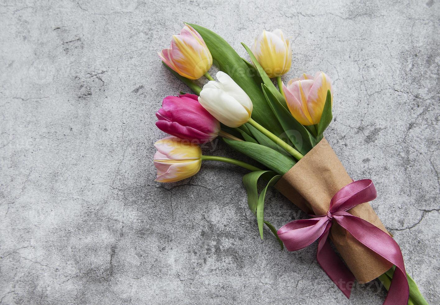 tulipes de printemps sur fond de béton photo