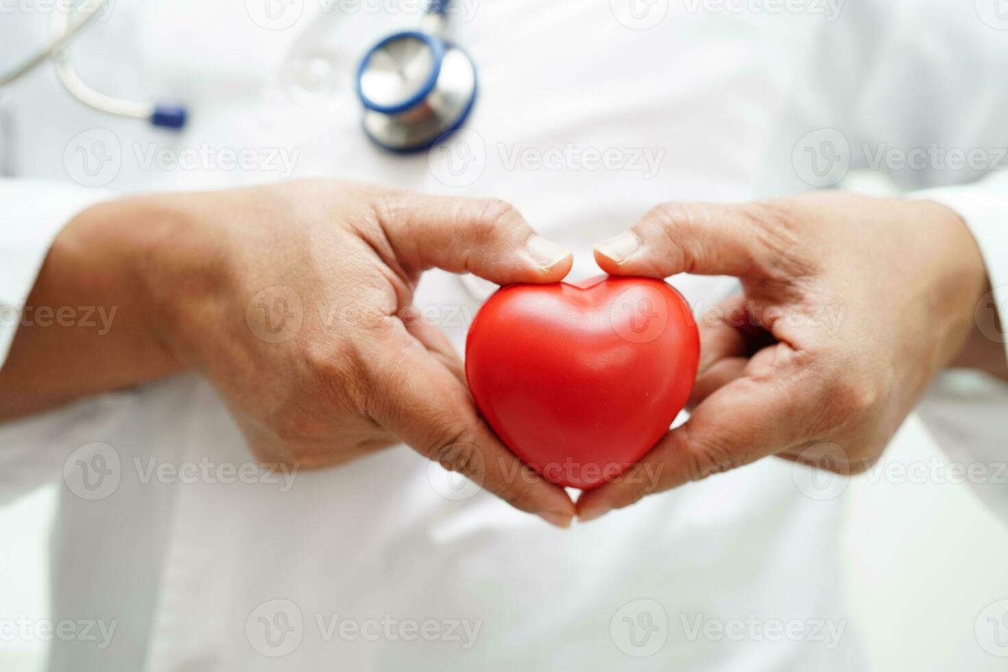 femme médecin asiatique tenant un coeur rouge pour la santé à l'hôpital. photo