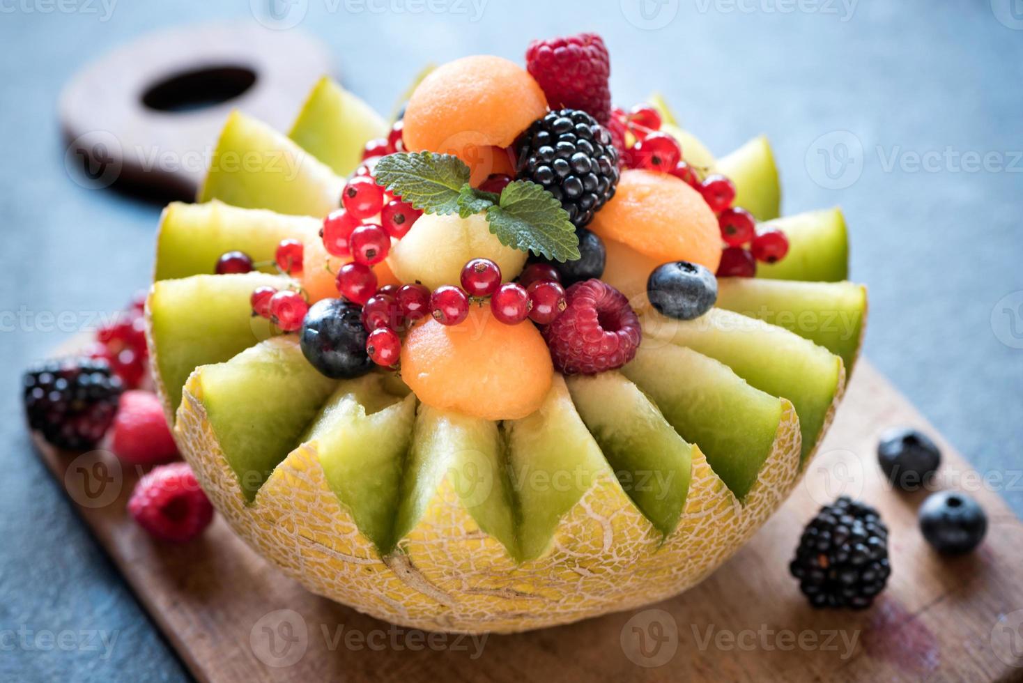 servi tranche melons avec baie des fruits photo