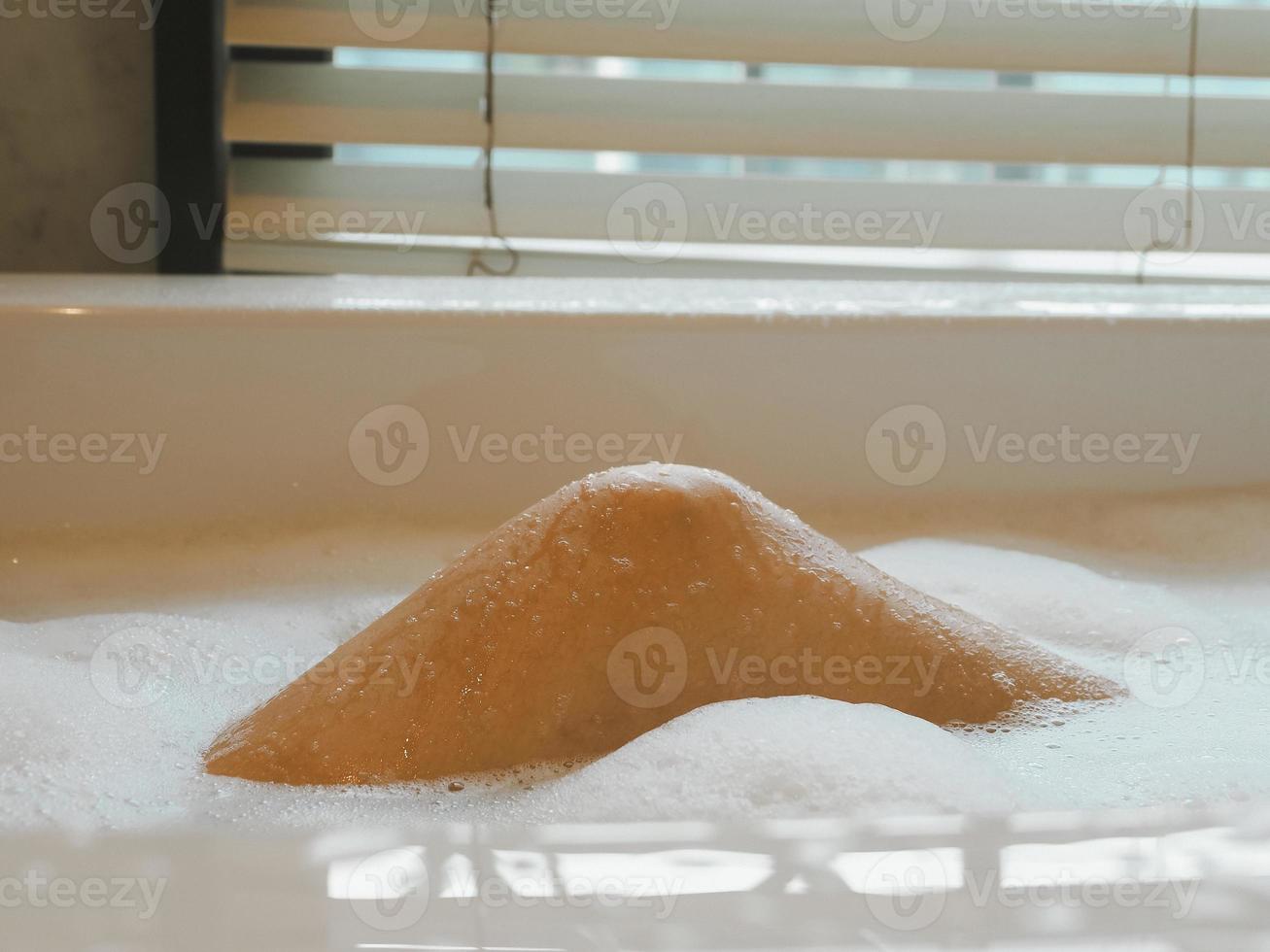 femelle jambes dans une baignoire mousse qui sont profiter et relaxant de infusion travail à peau se soucier spa photo