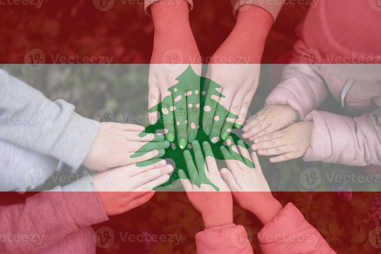 mains de des gamins sur Contexte de Liban drapeau. libanais patriotisme et unité concept. photo