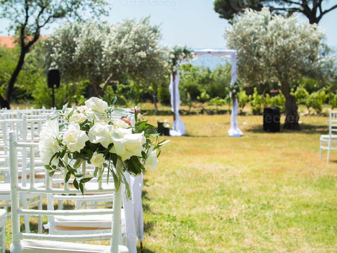 mariage cambre décoré avec tissu et fleurs en plein air. magnifique mariage ensemble en haut. mariage la cérémonie sur vert pelouse dans le jardin. partie de le de fête décor et floral arrangement. photo