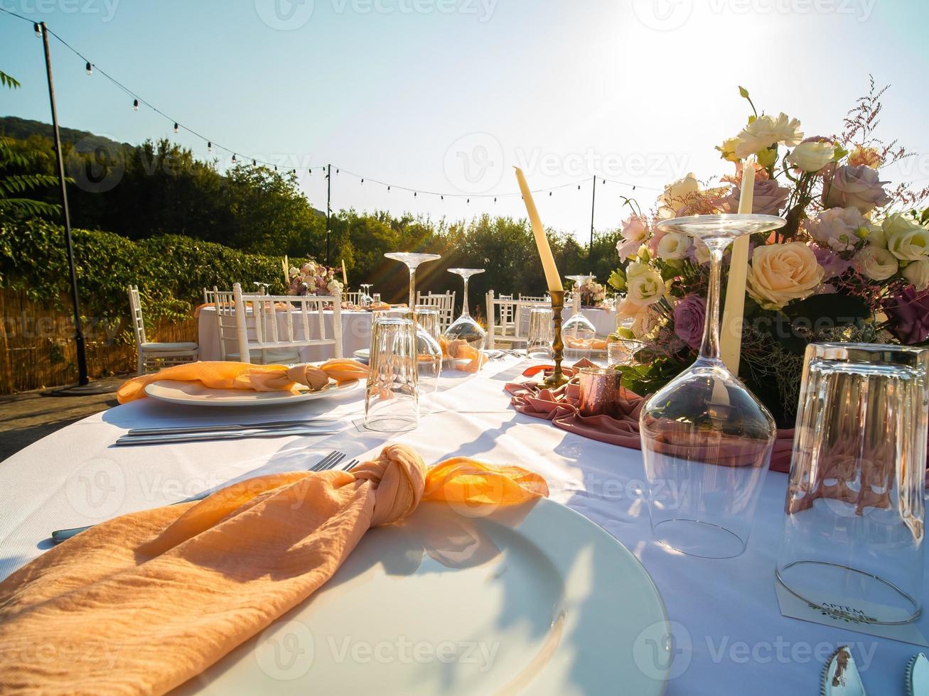 mariage banquet concept. chaises et rond table pour invités, servi avec coutelier et, fleurs et vaisselle et couvert avec une nappe de table photo