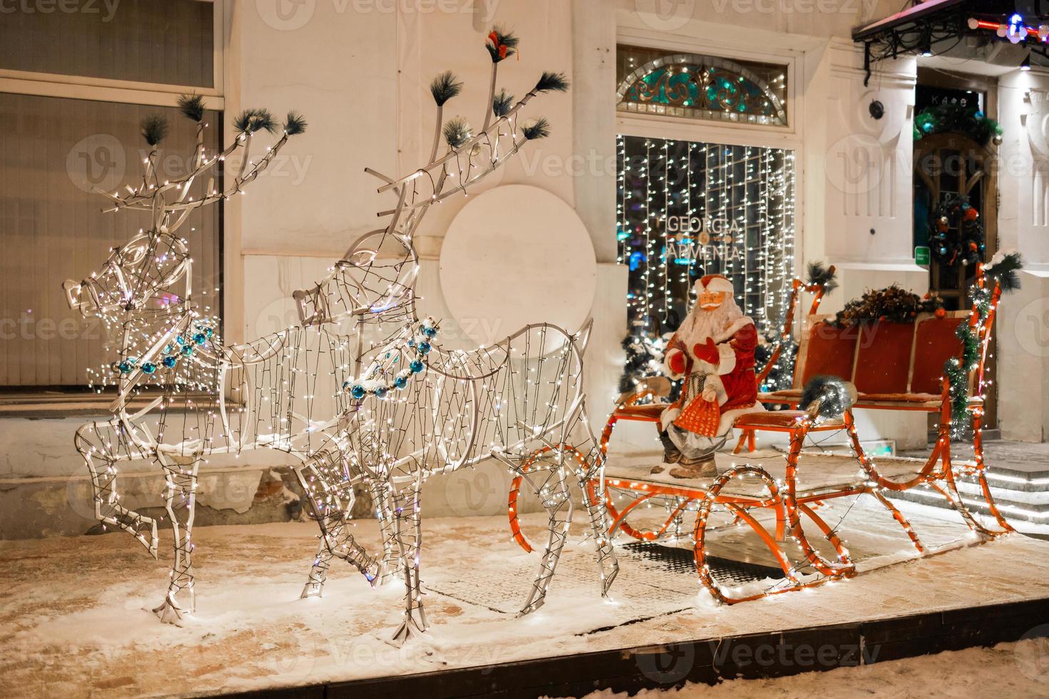 leds figure le père noël à cheval sur un traîneau pendant noël contre un restaurant ou un magasin dans la ville d'hiver de vacances - saison des fêtes et des vacances photo