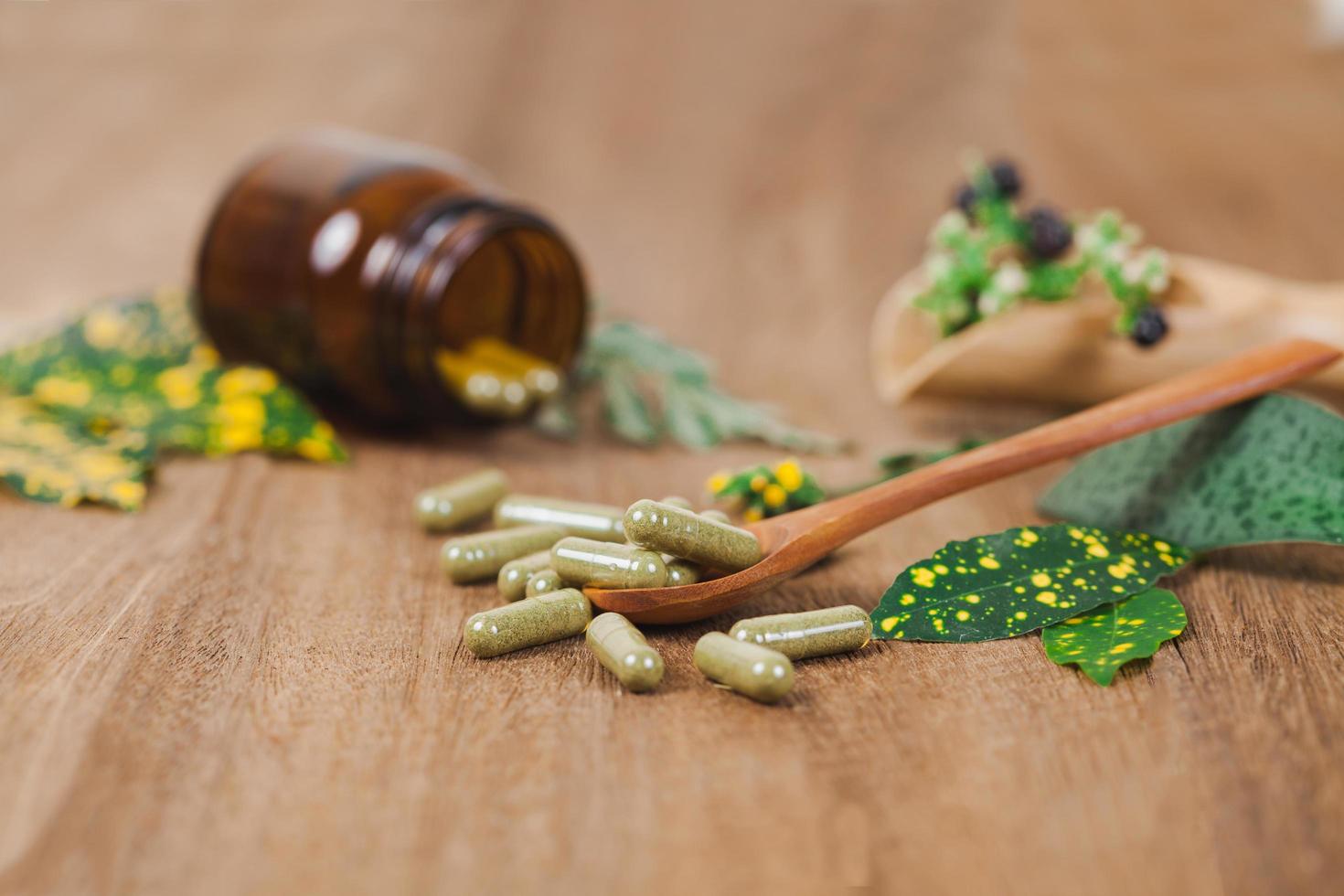 à base de plantes médicament capsules de herbe sur rustique en bois table pour en bonne santé en mangeant et bien la vie ,doux se concentrer. photo