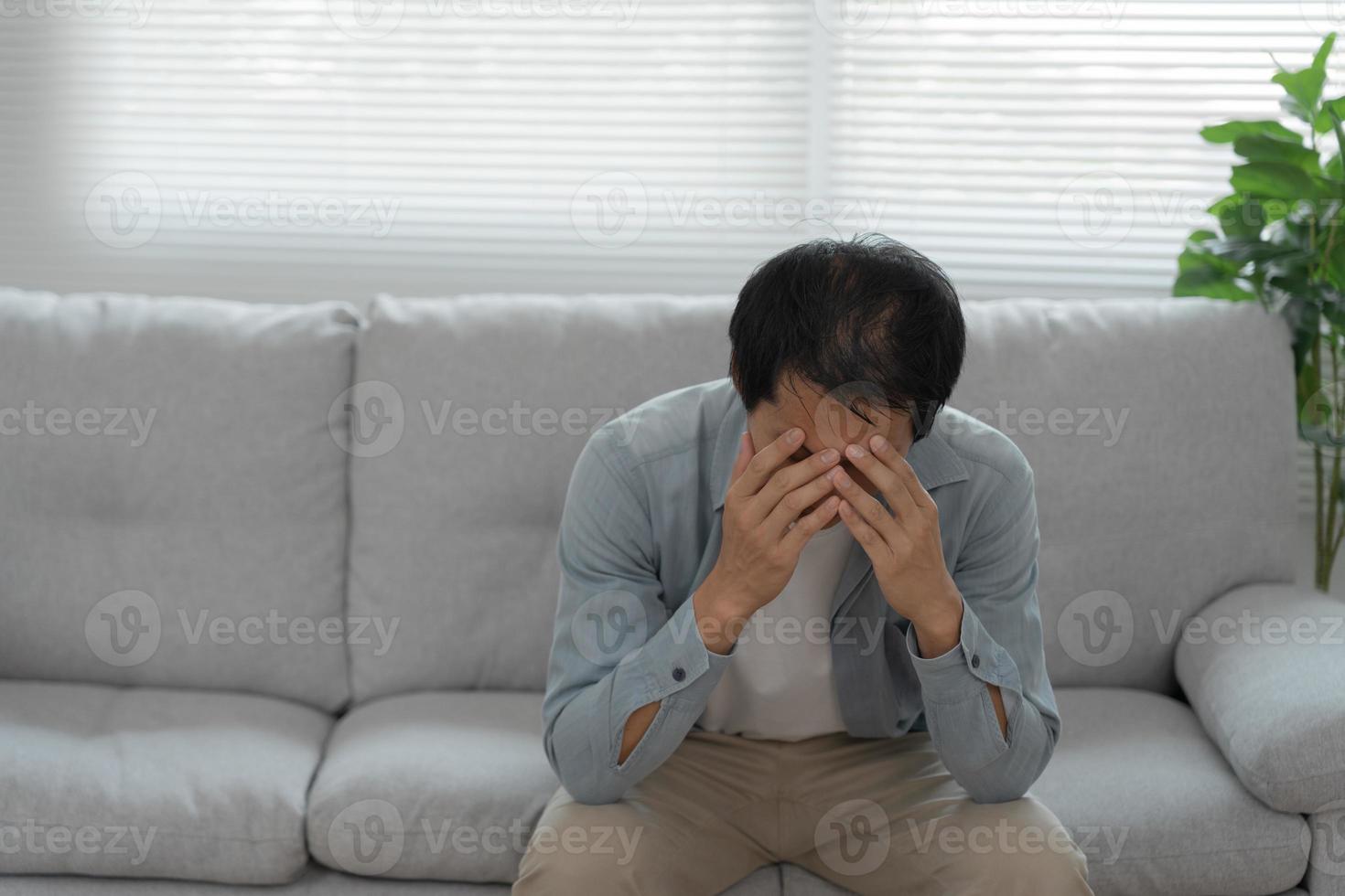 dépression et maladie mentale. un homme asiatique déçoit, triste après avoir reçu de mauvaises nouvelles. garçon stressé confus avec un problème malheureux, se disputant avec sa petite amie, pleurant et s'inquiétant d'un travail inattendu, d'une économie en baisse. photo