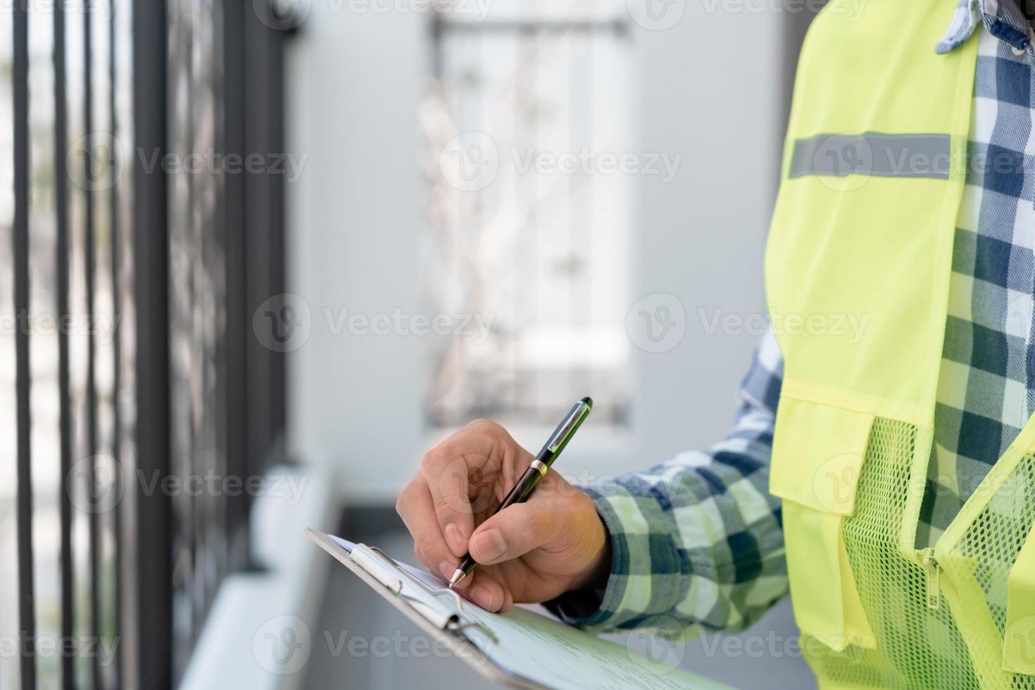 l'inspecteur ou l'ingénieur inspecte la construction et l'assurance qualité de la nouvelle maison à l'aide d'une liste de contrôle. ingénieurs ou architectes ou entrepreneur travaillent pour construire la maison avant de la remettre au propriétaire photo