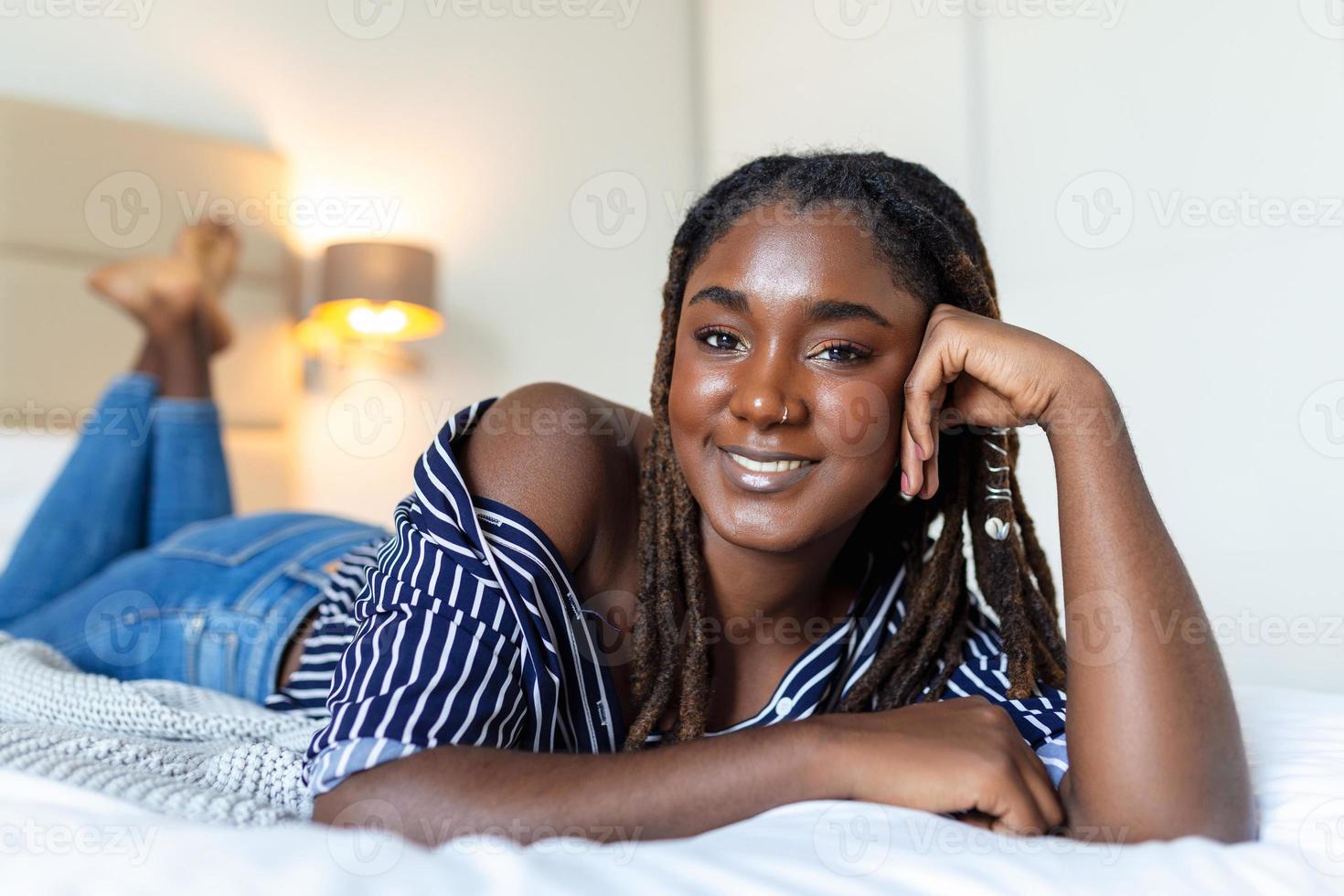 portrait de magnifique et portrait sensuel de magnifique et sensuel africain Jeune femme mensonge sur lit. magnifique femme mensonge dans lit africain Jeune femme mensonge sur lit. photo