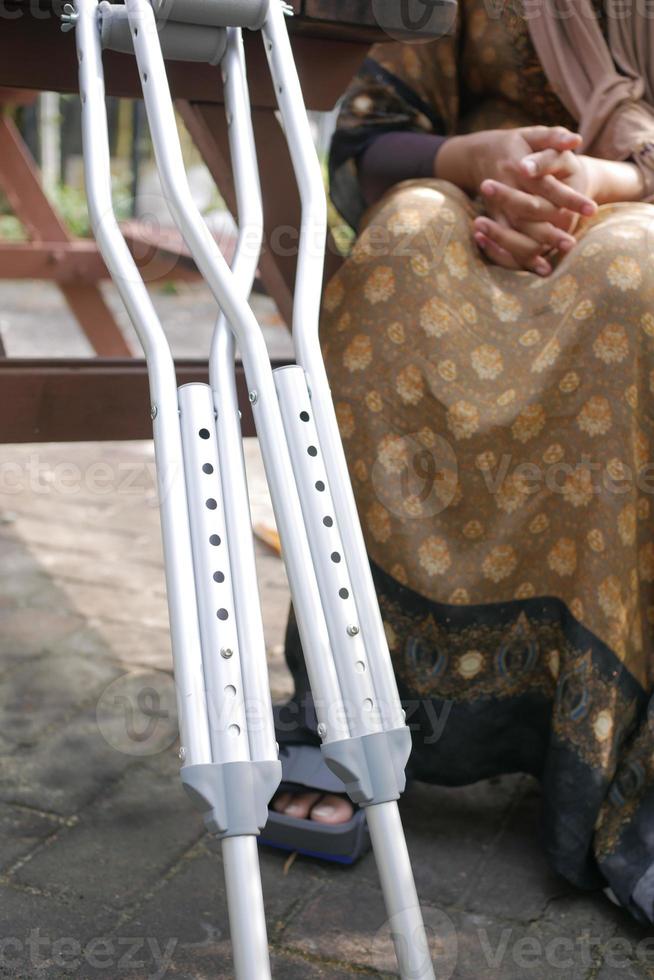 Jeune femmes avec cassé jambe sur béquilles. photo