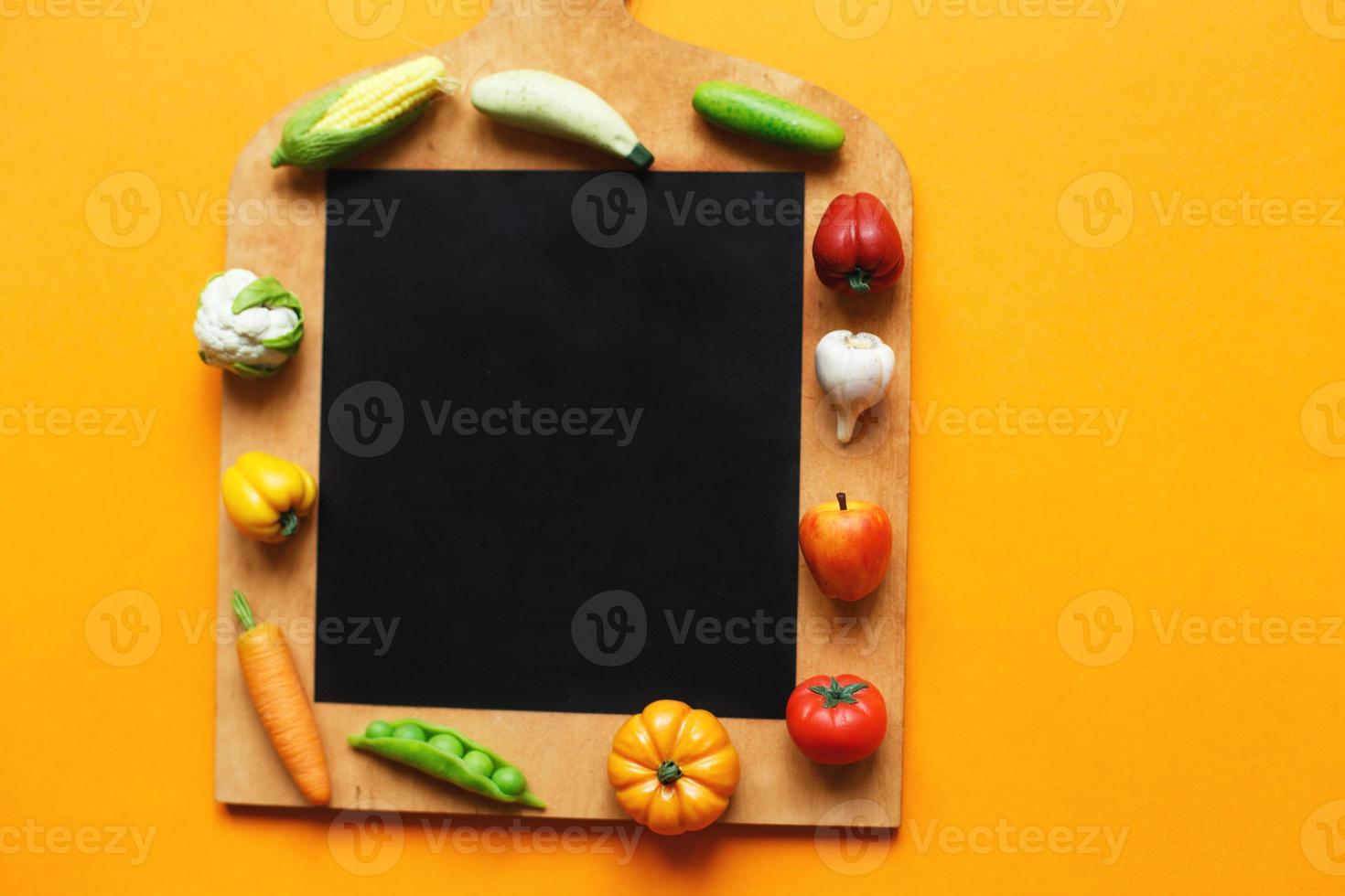 légumes et fruits sur la planche à découper sur fond jaune. concept de cuisine saine photo