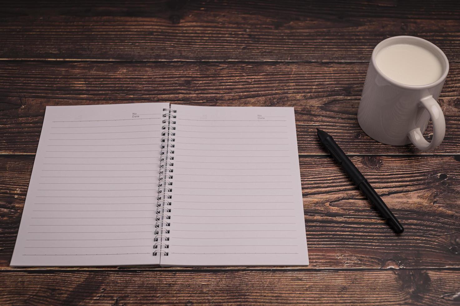 cahier et un verre de lait sur le bureau photo