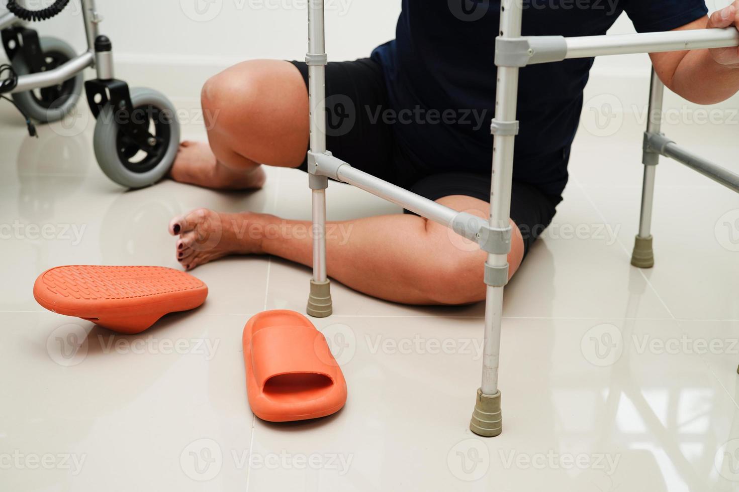 blessure d'une femme asiatique en tombant sur des surfaces glissantes avec une marchette à la maison. photo