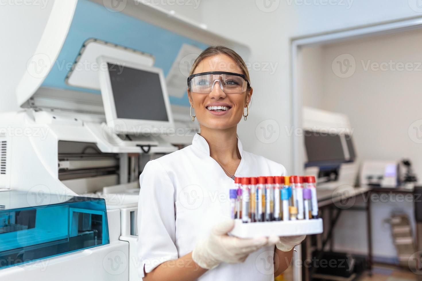 du sang tester tubes. femelle scientifique examiner du sang tester tubes à sa laboratoire ADN essai une analyse profession spécialiste clinicien expérimenté médicament soins de santé médecin photo
