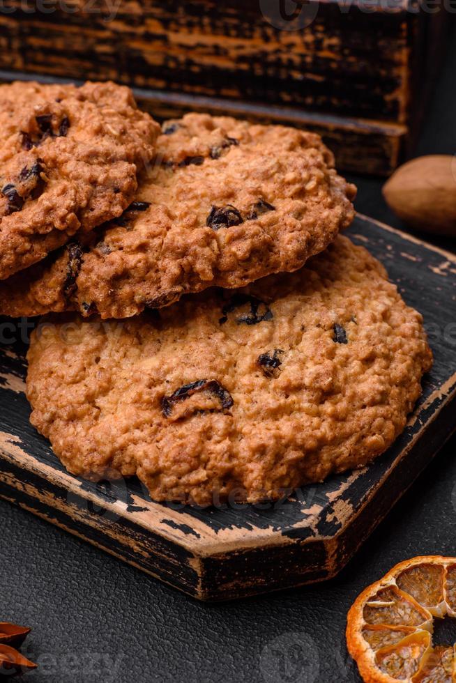 délicieux cuit flocons d'avoine raisin biscuits sur une foncé béton Contexte photo