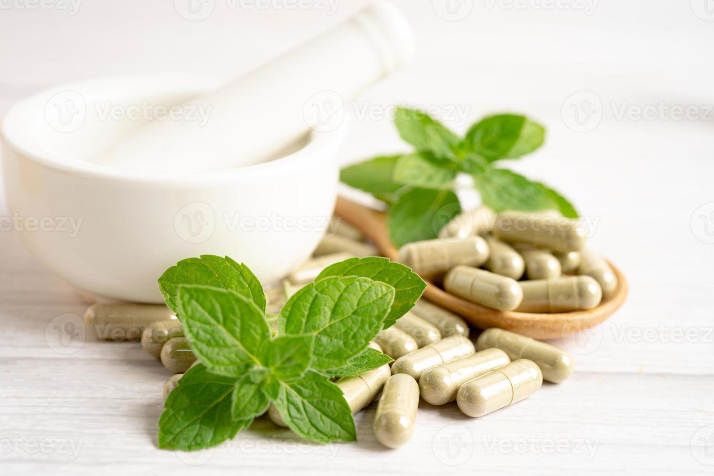 capsule biologique à base de plantes de médecine alternative avec vitamine e oméga 3 huile de poisson, minéral, médicament avec feuilles d'herbes suppléments naturels pour une bonne vie saine. photo