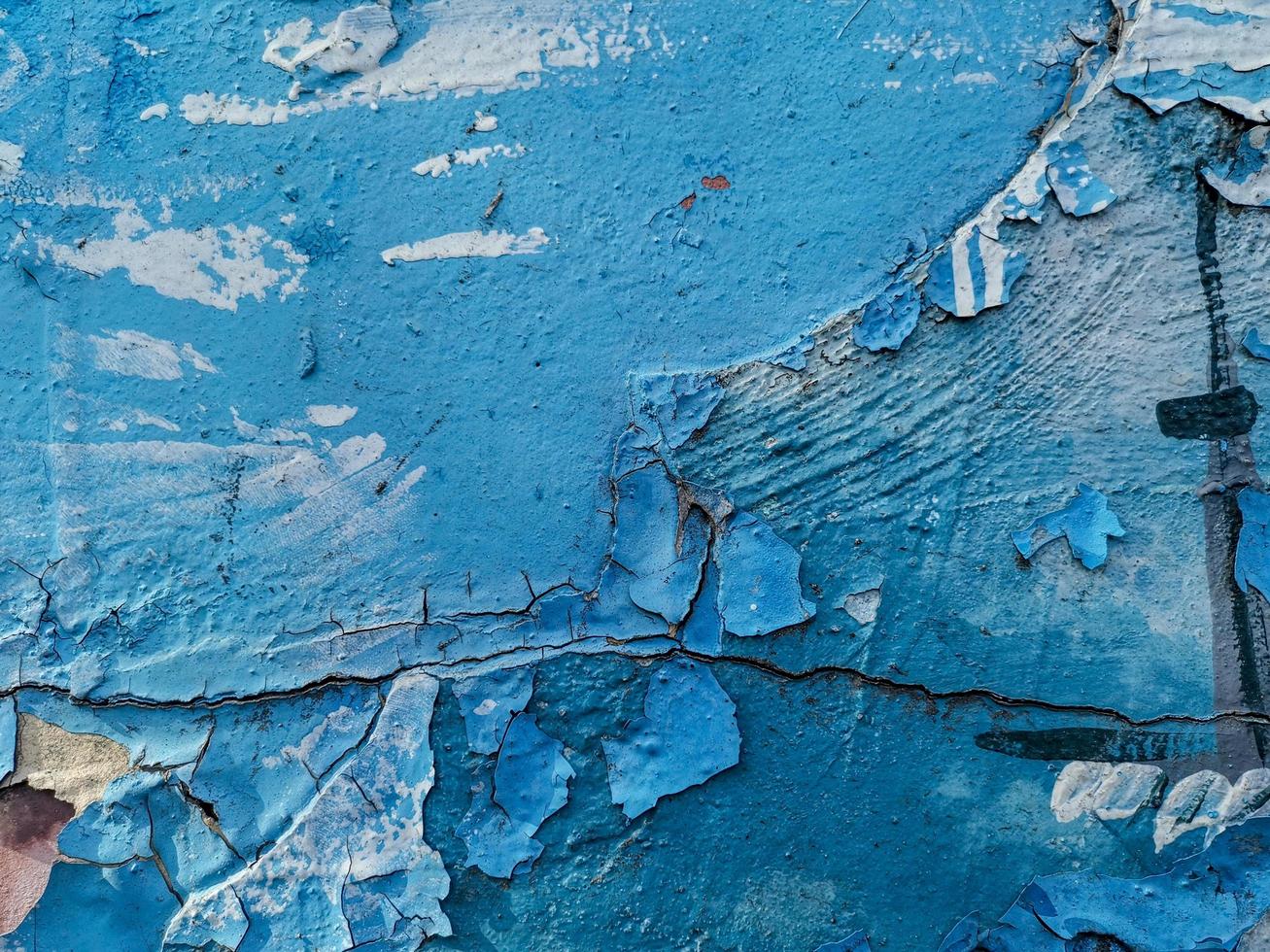 fond bleu avec de la peinture à l'huile craquelée sur du plâtre. photo