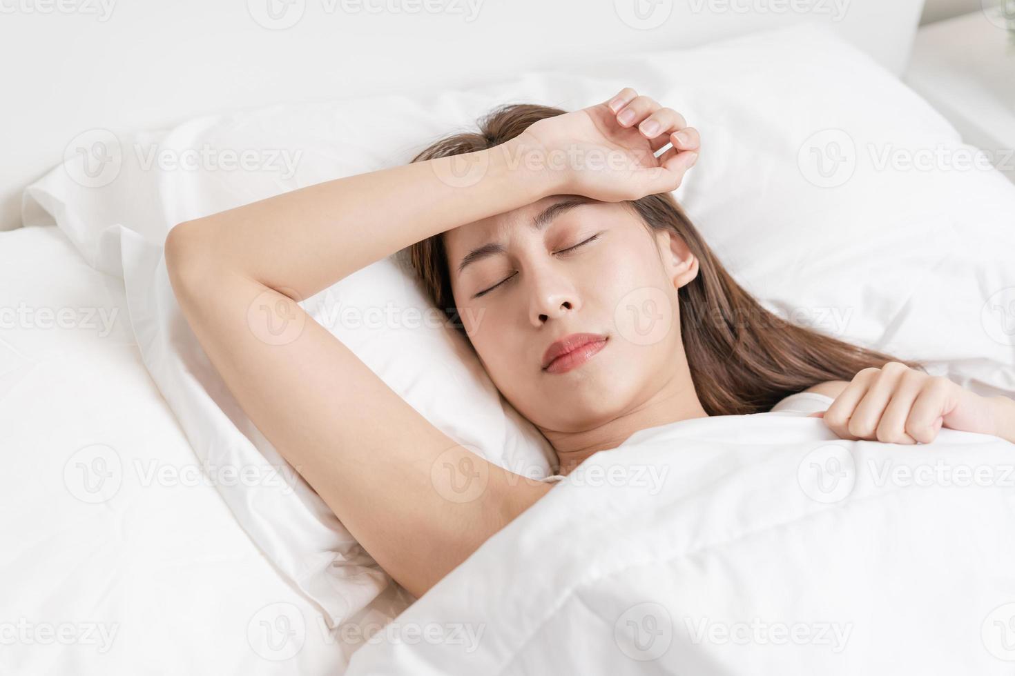 sucré rêves, attrayant sourire jolie asiatique Jeune femme, fille en train de dormir dans confortable lit mensonge sur doux oreiller repos, en gardant yeux fermé tandis que avec couvert couverture dans confortable blanc lit dans le Matin. photo