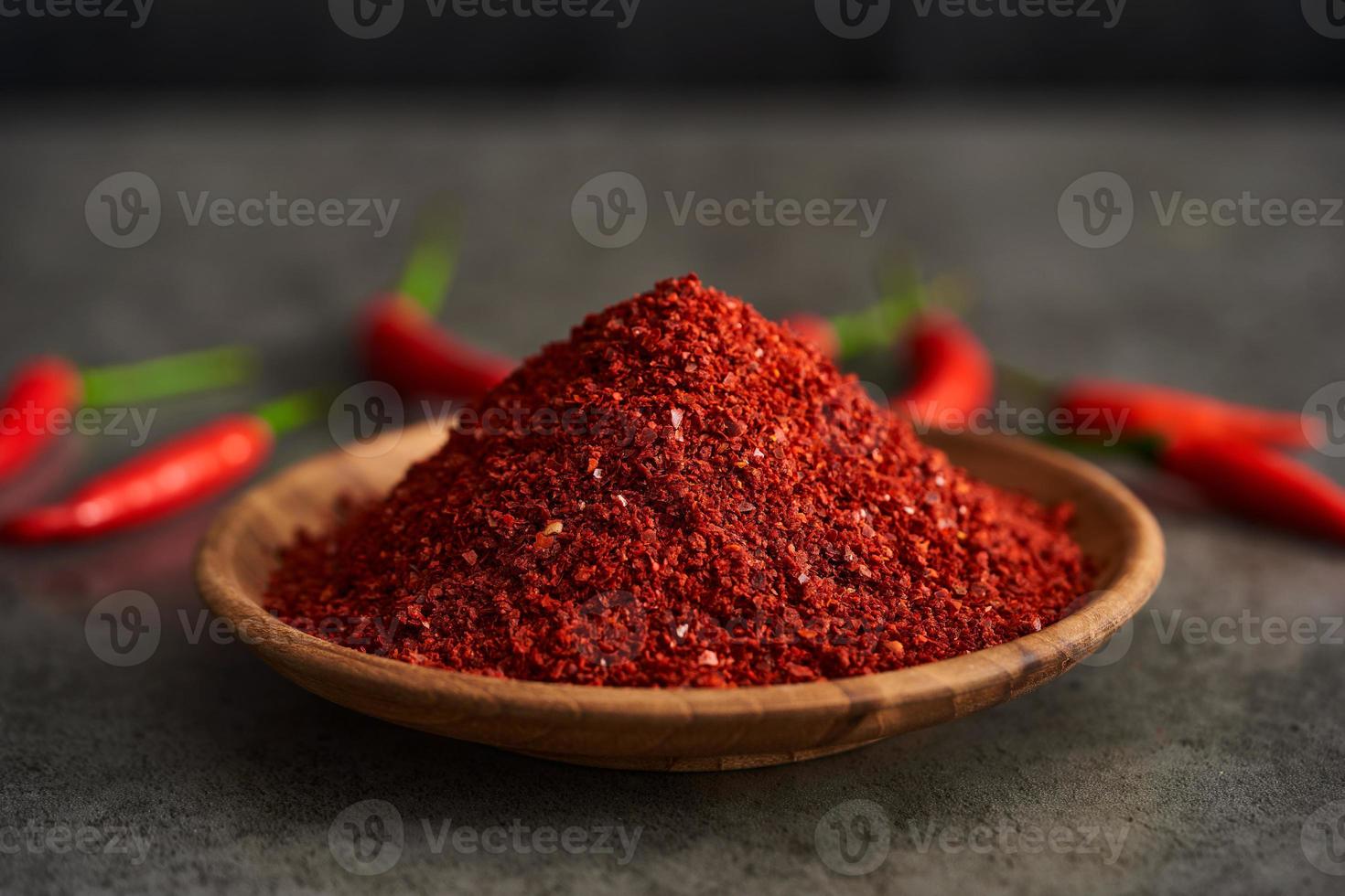 rouge le Chili poivre flocon ou sol poudre grossier dans bois bol sur gris pierre nourriture Contexte. rouge le Chili poivre flocon ou sol poudre grossier aliments. rouge le Chili poivre flocon ou sol poudre grossier photo