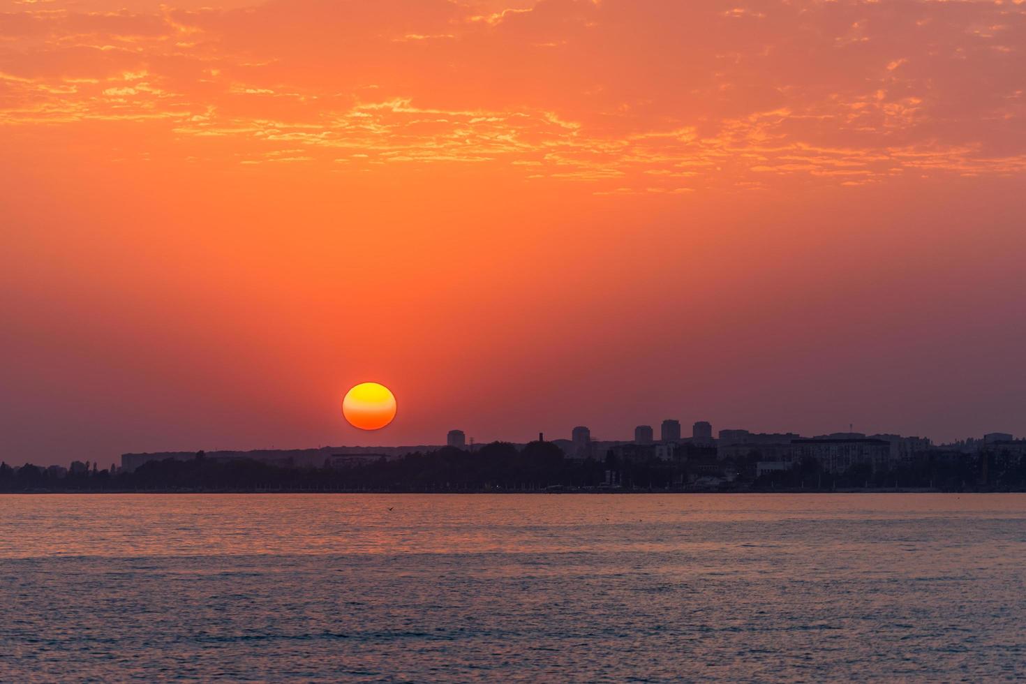 coucher de soleil lumineux sur une mer calme et un ciel coloré photo