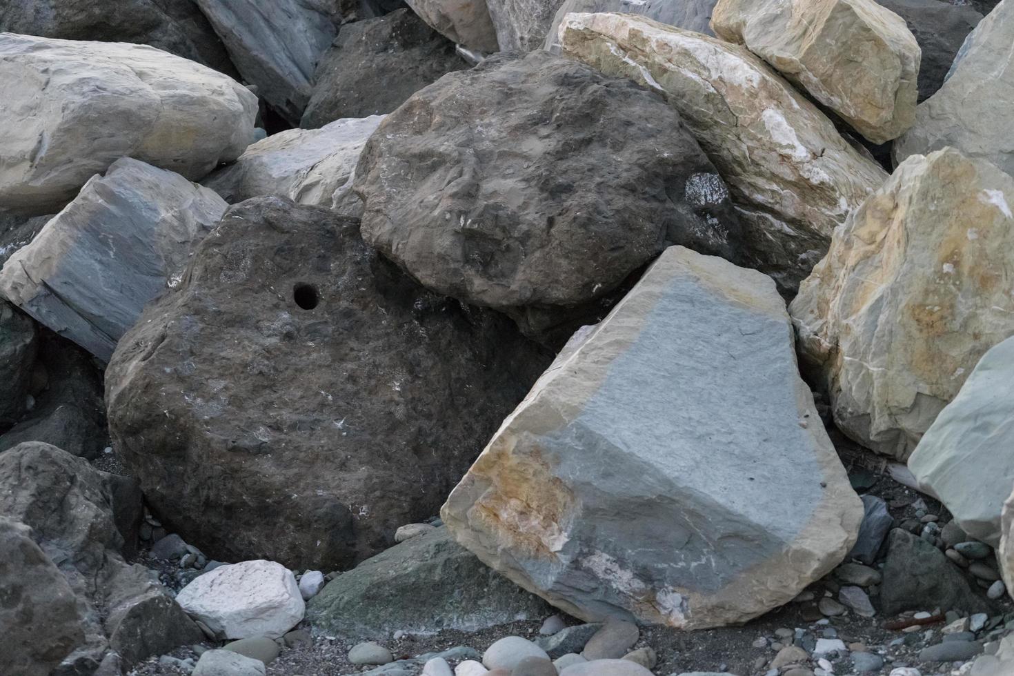 d'énormes pierres gisant sur la mer pour protéger le rivage du flou photo