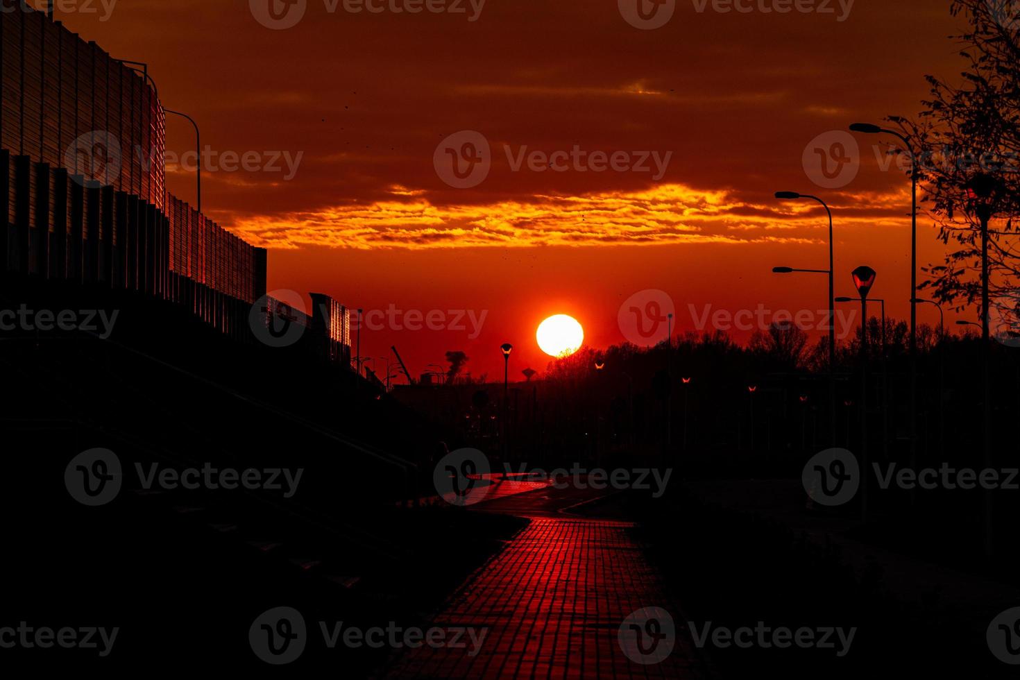 rouge le coucher du soleil dans le ville avec une route et en marchant couple de gens dans l'amour photo