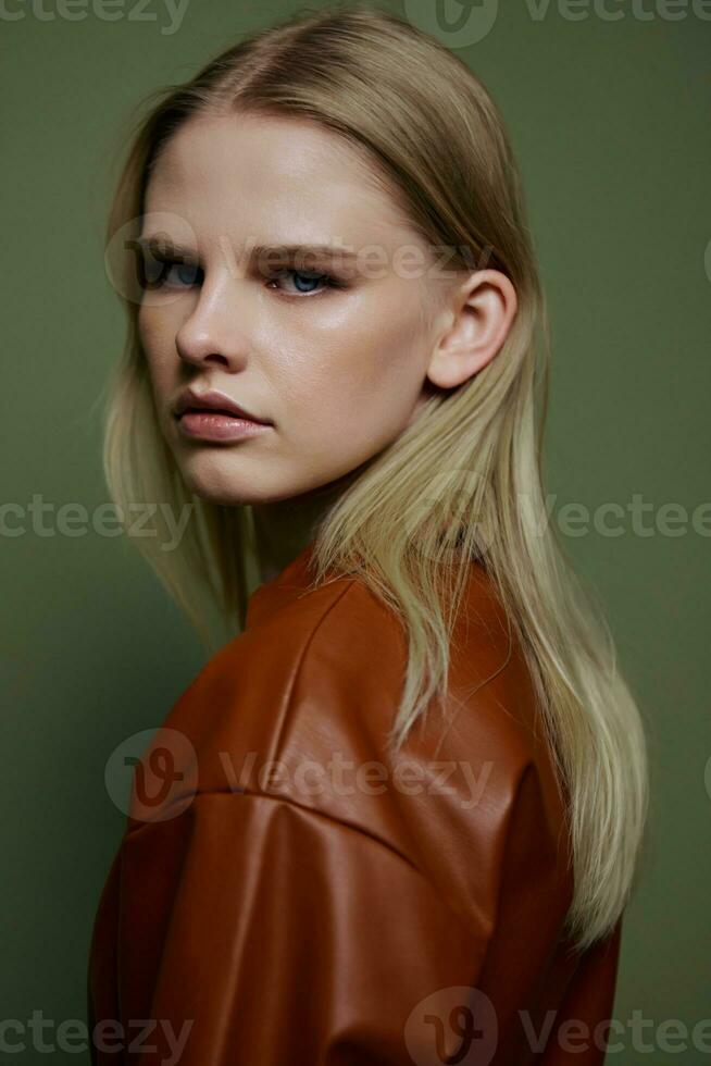 photo du visage portrait de élégant sur de soi professionnel blond modèle regards à caméra. fermer coup dans studio sur plus de olive vert Contexte